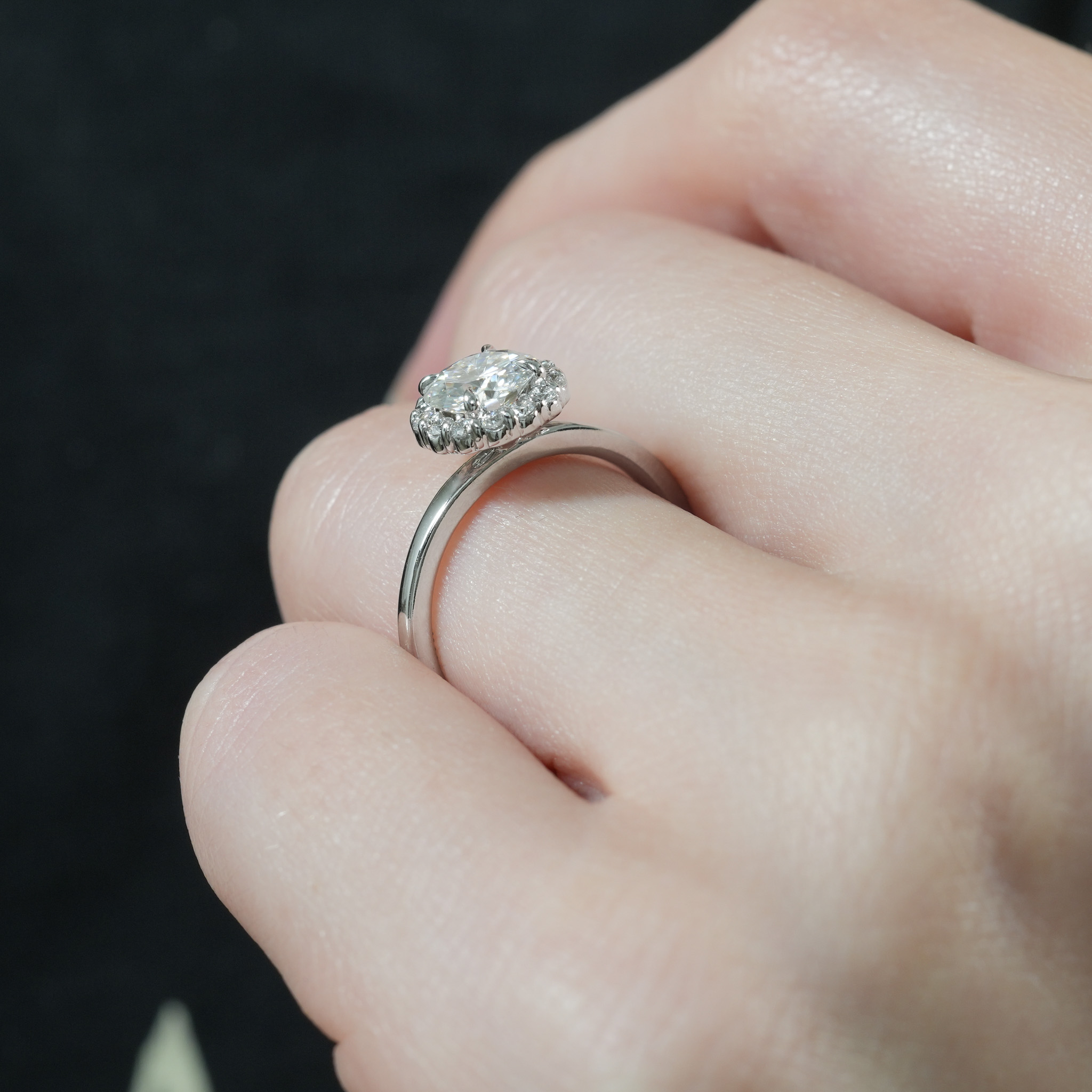 Angle view of floral halo engagement ring in lifestyle