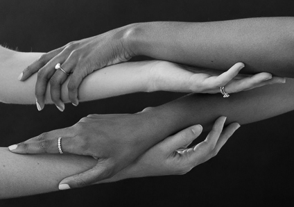 hands intertwined wearing ethical engagement rings in white gold