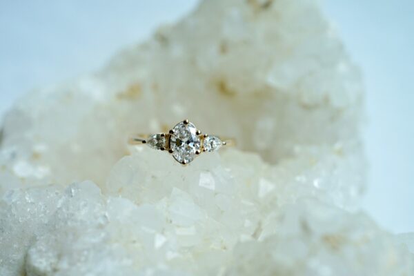 CUSTOM-Tapered-Three-Stone-6.6×4.7mm-Oval-Diamond-with-Pear-Side-Stones-YG-Surface-Crystal-scaled