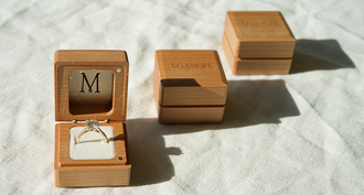 http://three%20sustainable%20wooden%20engagement%20ring%20boxes%20in%20sunlight%20on%20cream%20surface