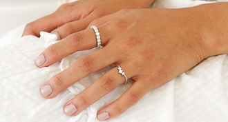 http://hands%20on%20white%20dress%20showing%20two%20diamond%20rings%20on%20different%20fingers