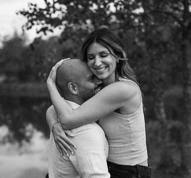 black and white photo of a man holding a woman while woman gives man a hug