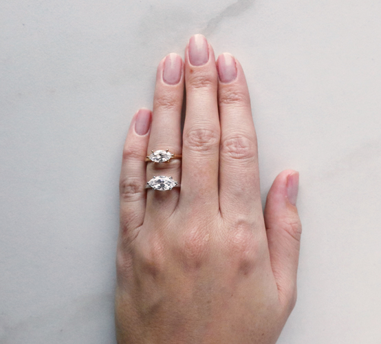 two engagement rings with marquise diamonds set horizontally on a hand