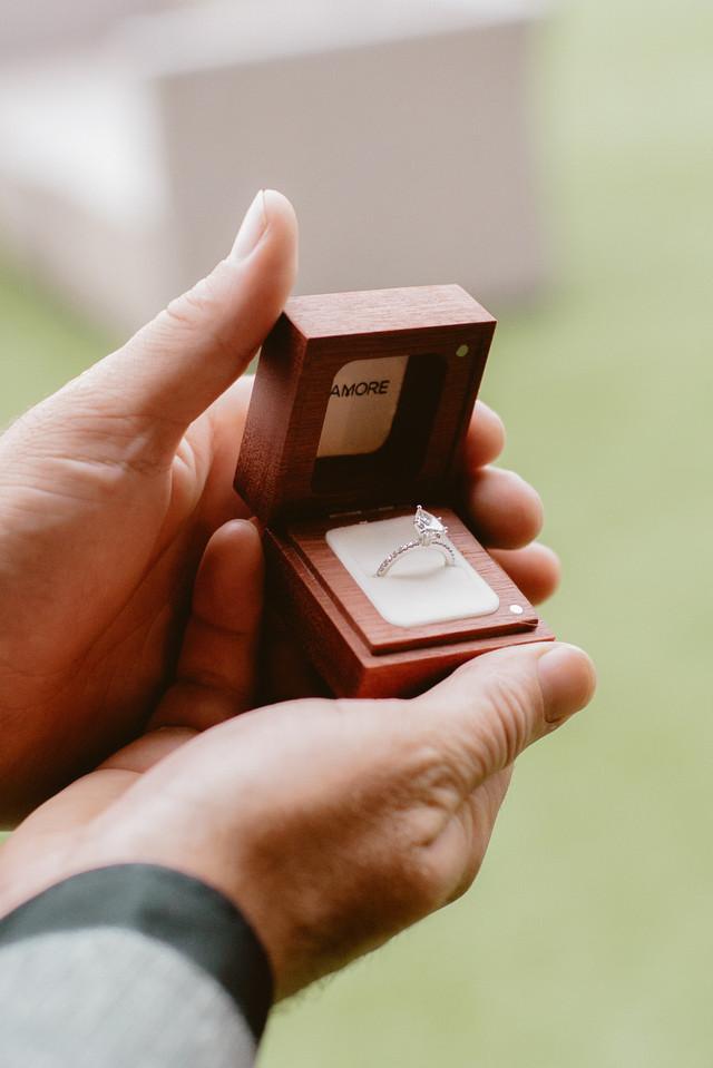 man holding ring box showing off engagement ring