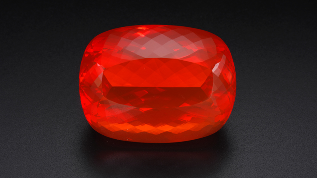 bright red oval stone on black background