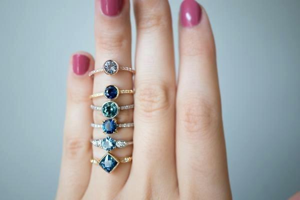 stack of montana sapphire engagement rings on ring finger in gold