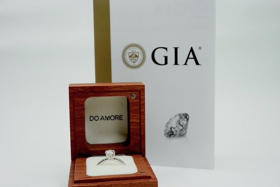 wooden engagement ring box in front of GIA diamond grading report