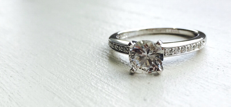 An engagement ring featuring a round white sapphire