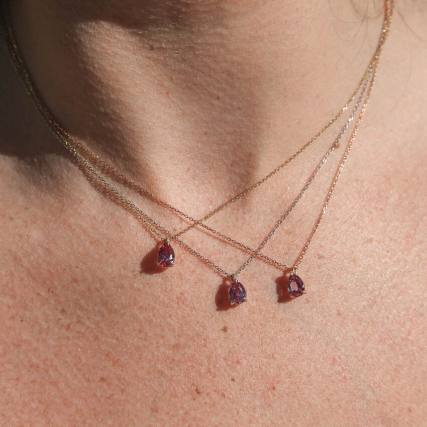 person wearing three pear shaped pendant necklaces in white gold rose gold and yellow gold