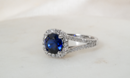 Round blue sapphire in a halo split shank setting