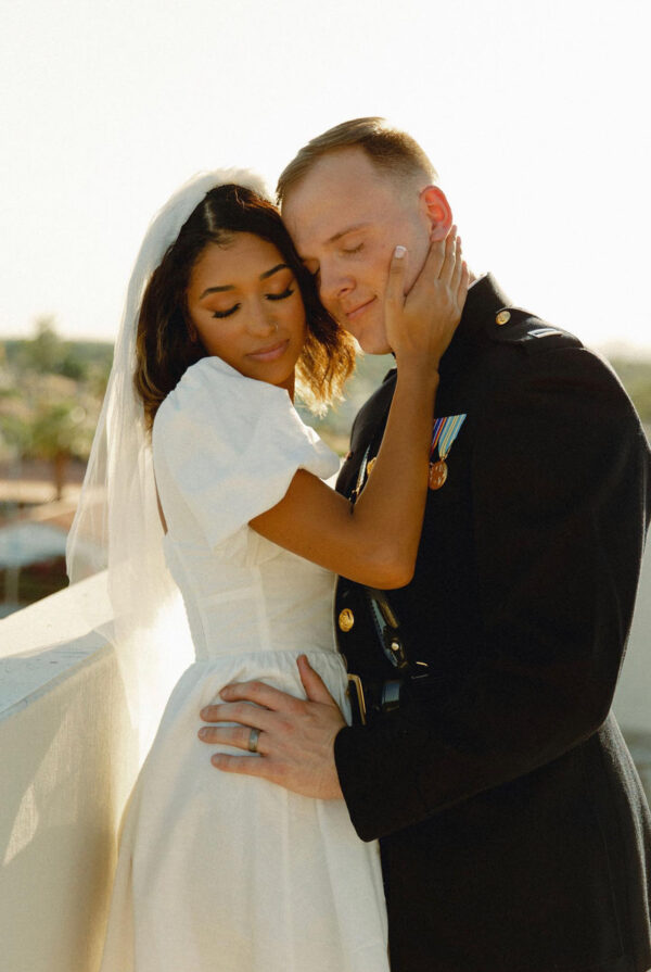 Girl holding husbands face while showing off engagement ring