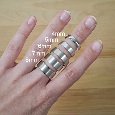 hand showcasing 5 wedding bands of increasing width on middle finger