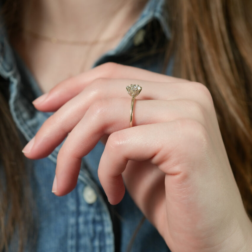 Angle view of pave petal prong engagement ring in lifestyle