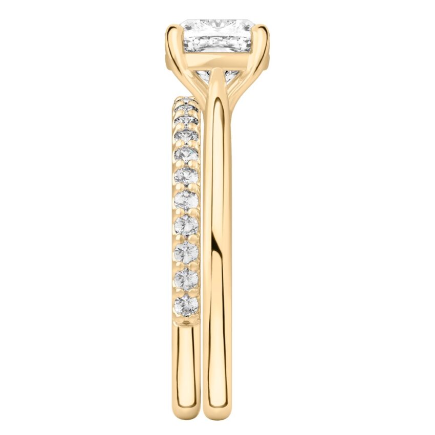 Side view of cushion cut diamond cathedral solitaire engagement ring set yellow gold