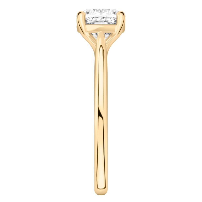 Side view of cushion cut diamond cathedral solitaire engagement ring yellow gold