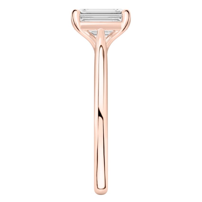 Side view of emerald cut diamond cathedral solitaire engagement ring rose gold