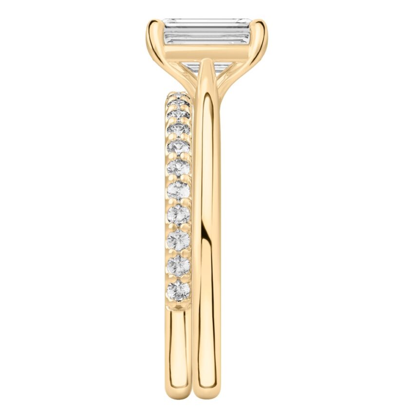 Side view of emerald cut diamond cathedral solitaire engagement ring set yellow gold
