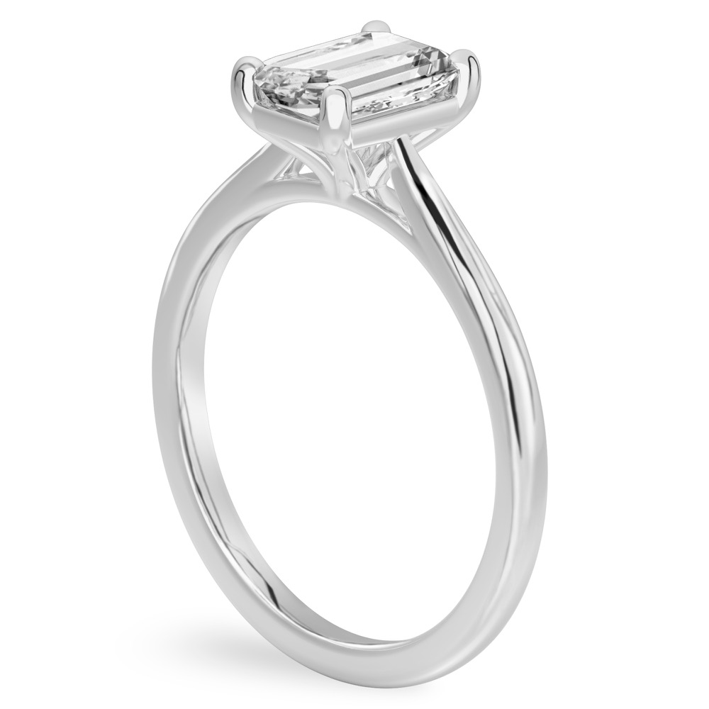 Angle view of emerald cut diamond cathedral solitaire engagement ring white gold