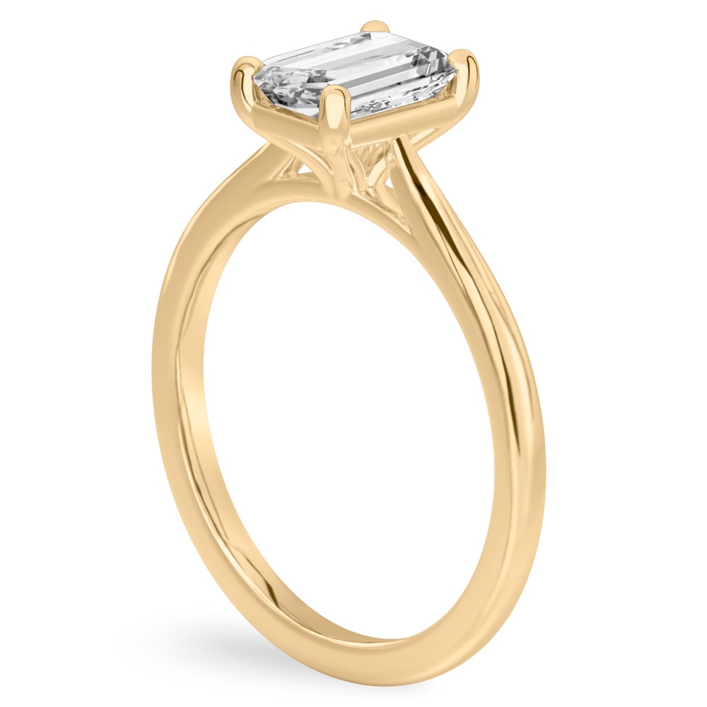 Angle view of emerald cut diamond cathedral solitaire engagement ring yellow gold