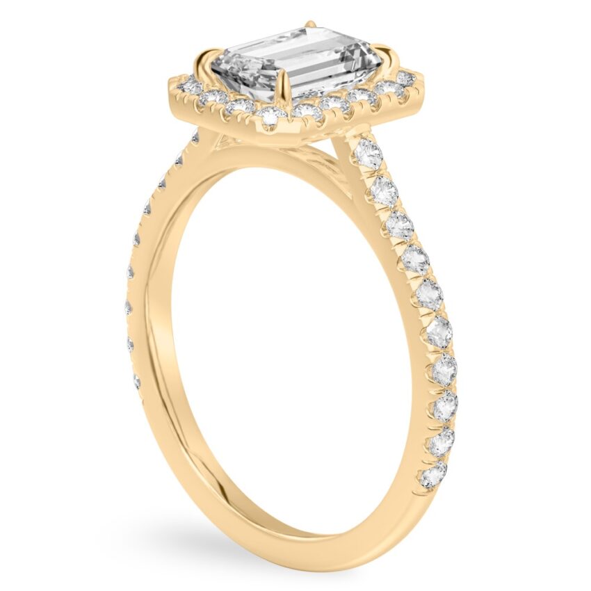 Angle view of emerald cut diamond cushion halo engagement ring yellow gold