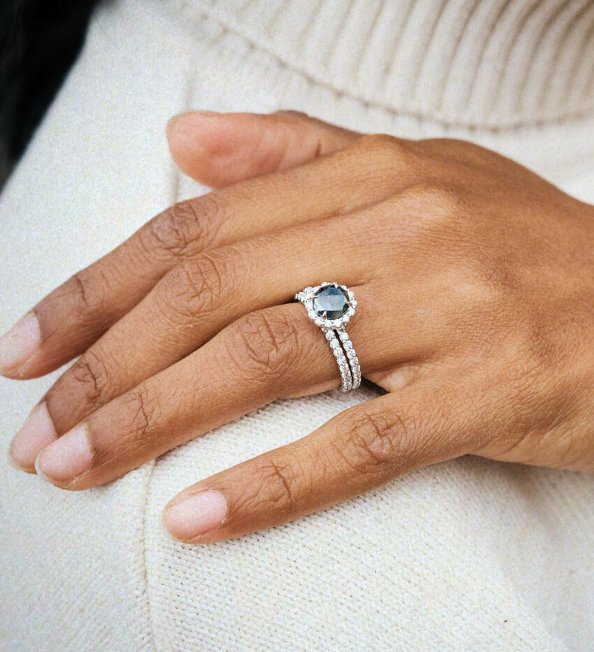 lifestyle image of dark between stars engagement ring and wedding band on model's hand