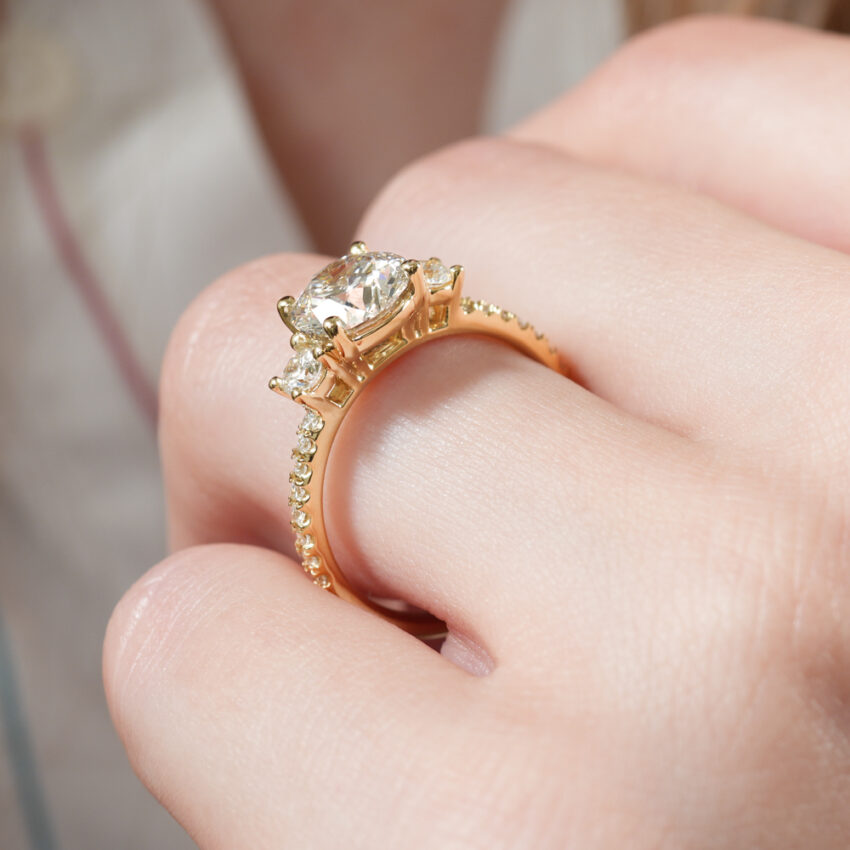 Angle view of pave three stone engagement ring in lifestyle