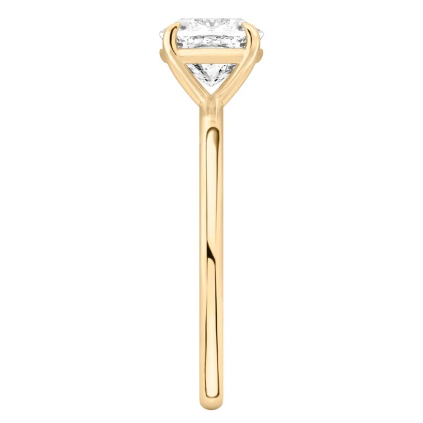 Side view of cushion cut diamond delicate solitaire engagement ring yellow gold