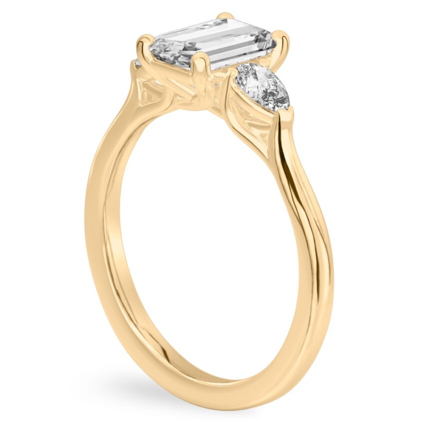 emerald cut diamond pear side stone engagement ring yellow gold angle