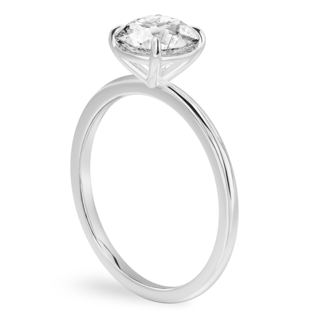 Angle view of four prong round cut diamond delicate solitaire engagement ring palladium