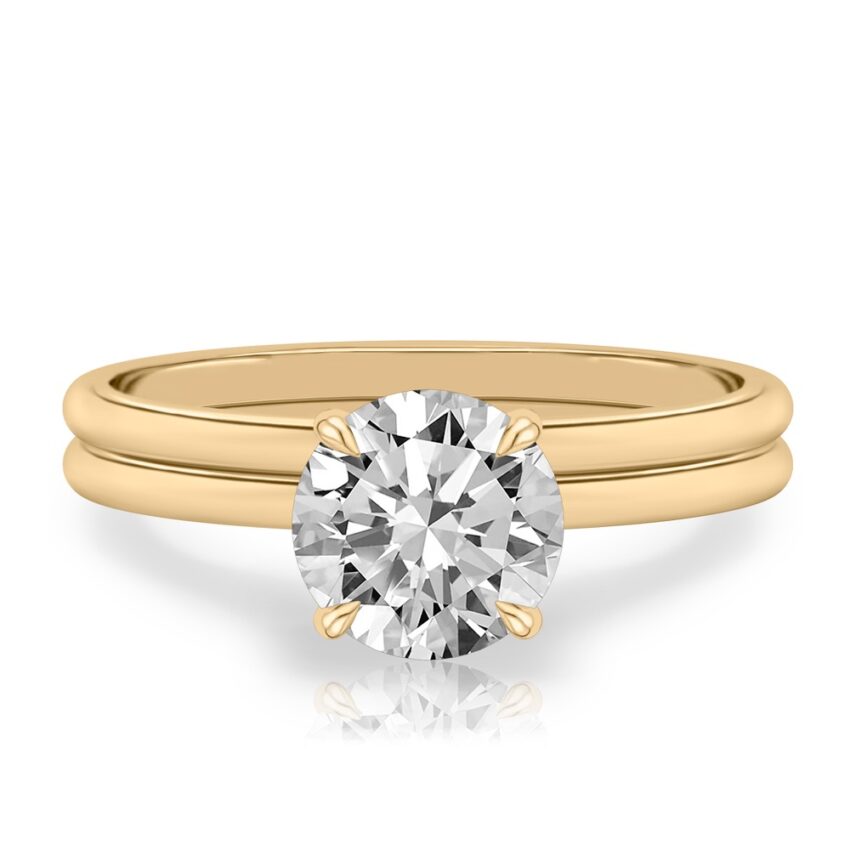 four prong round cut diamond delicate solitaire engagement ring in set yellow gold