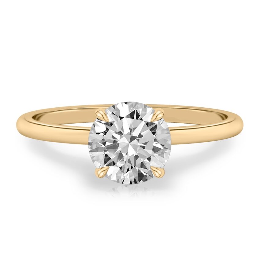 four prong round cut diamond delicate solitaire engagement ring in yellow gold