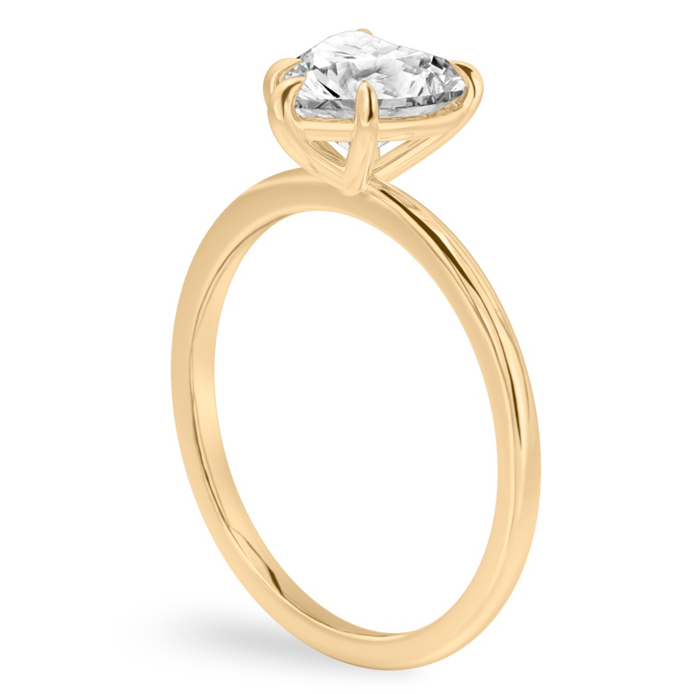Angle view of heart shape diamond delicate solitaire engagement ring yellow gold