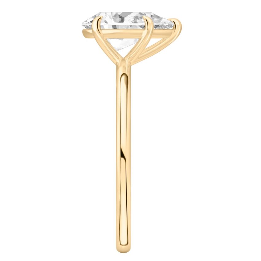Side view of pear shape diamond delicate solitaire engagement ring yellow gold
