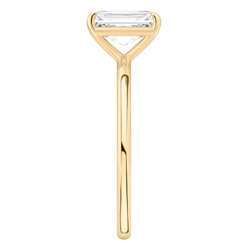 Side view of radiant cut diamond delicate solitaire engagement ring yellow gold