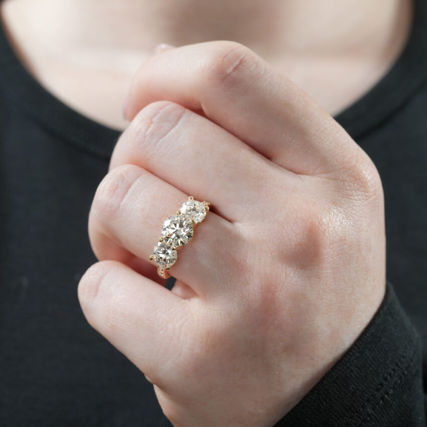 Video of three stone hidden halo engagement ring in lifestyle