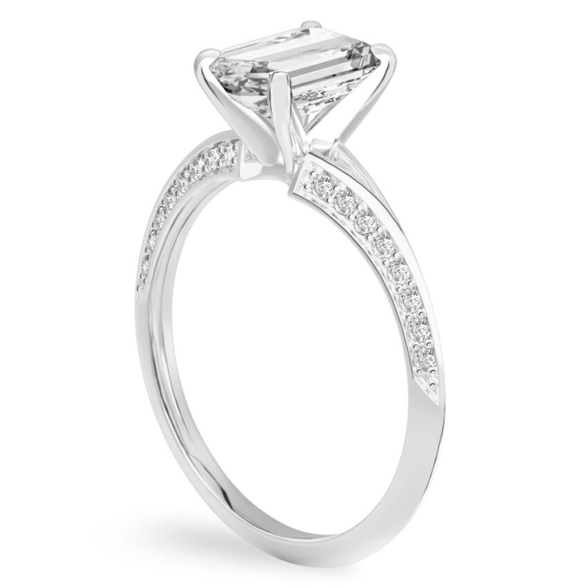 Angle view of emerald cut diamond split shank knife edge engagement ring in palladium
