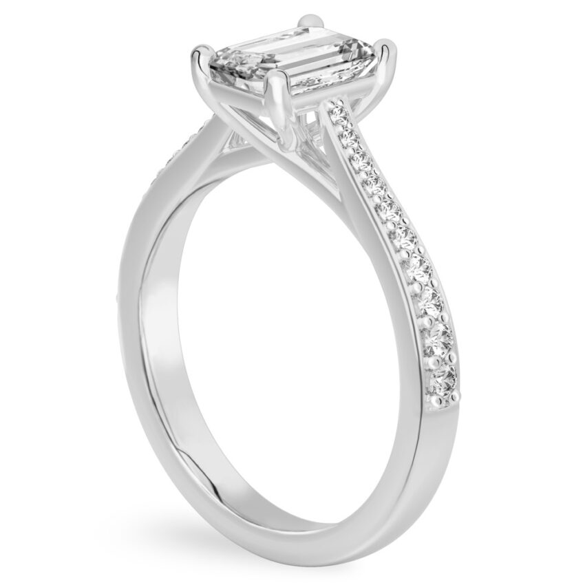 Angle view of emerald cut diamond tapered engagement ring in platinum