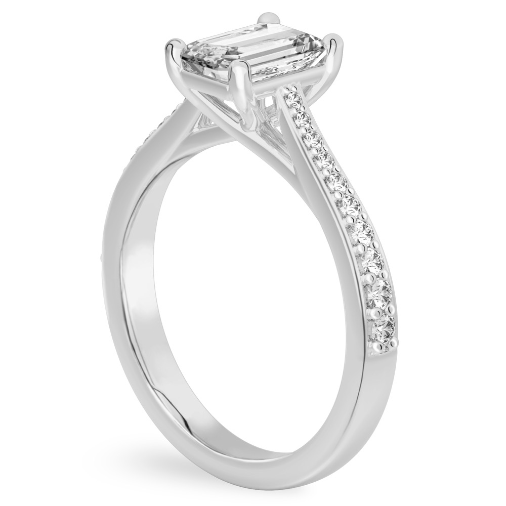 Angle view of emerald cut diamond tapered engagement ring in platinum