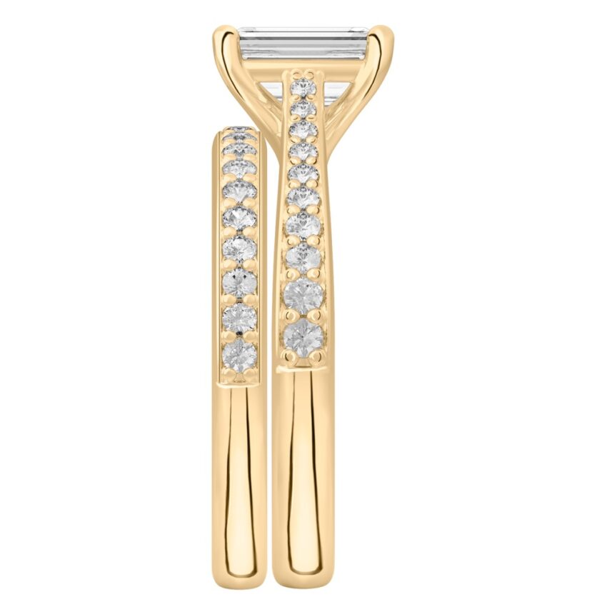 Side view of emerald cut diamond tapered engagement ring set yellow gold
