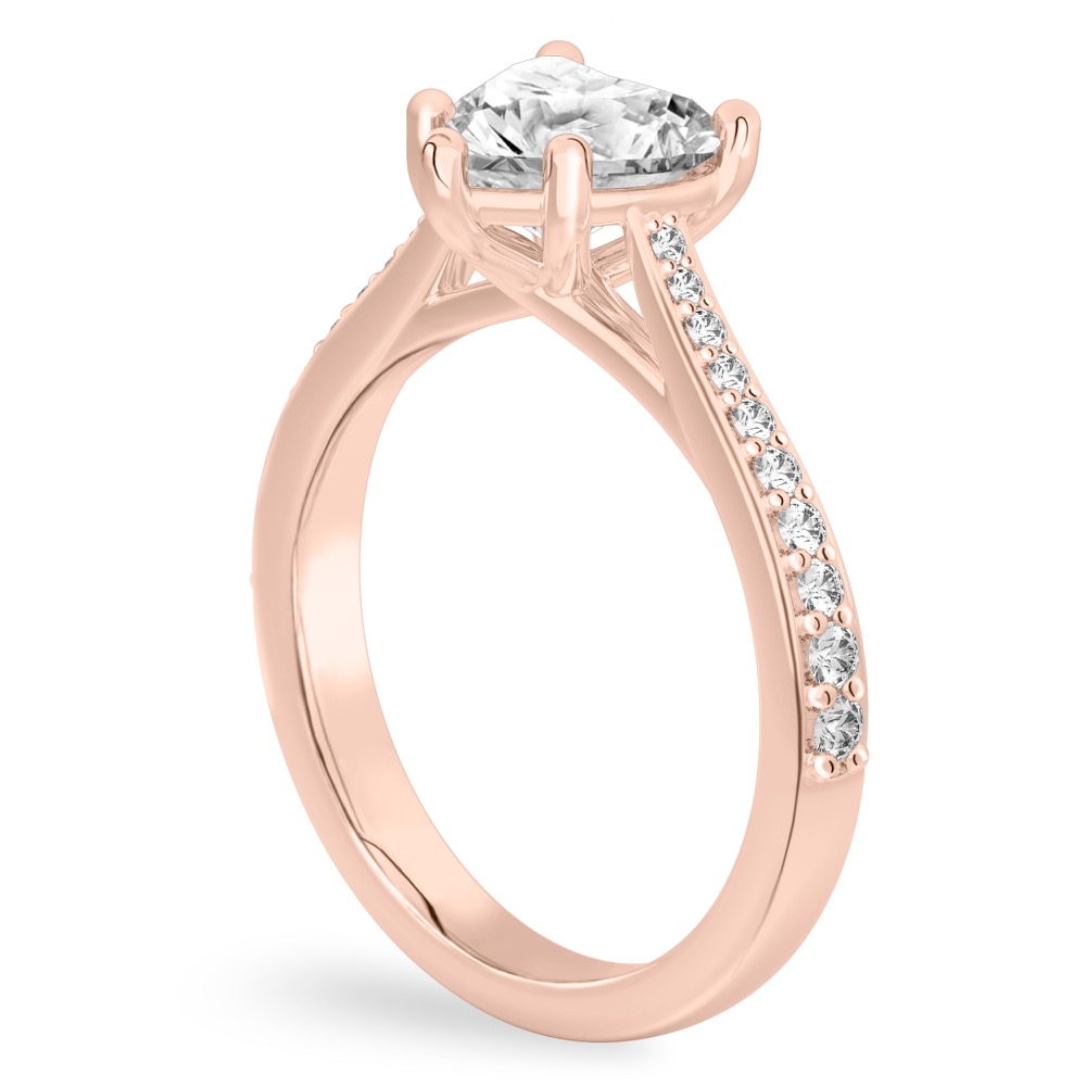 Angle view of heart shape diamond tapered engagement ring in rose gold