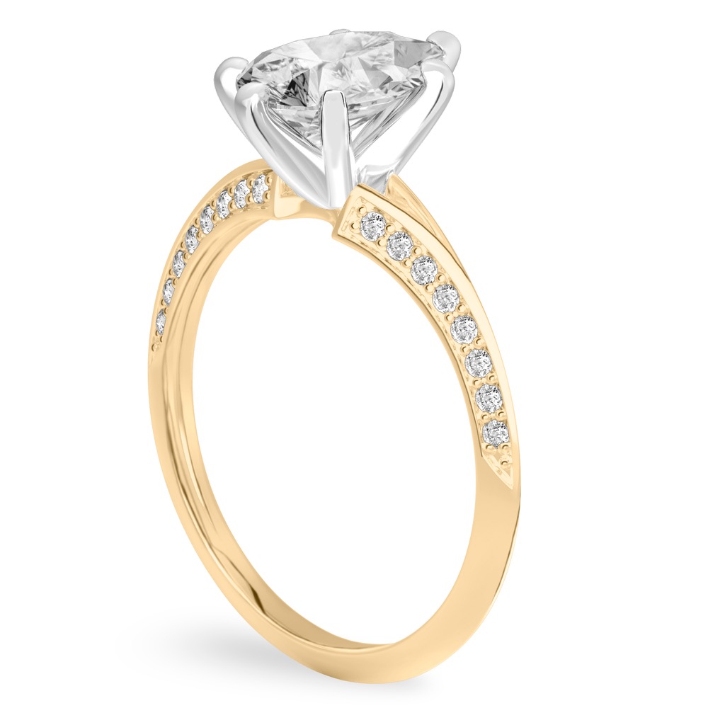 Angle view of pear shape diamond split shank knife edge engagement ring in yellow gold