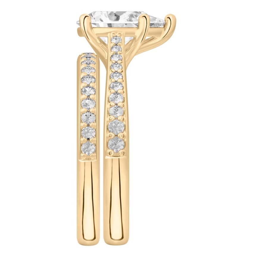 Side view of pear shape diamond tapered engagement ring set yellow gold