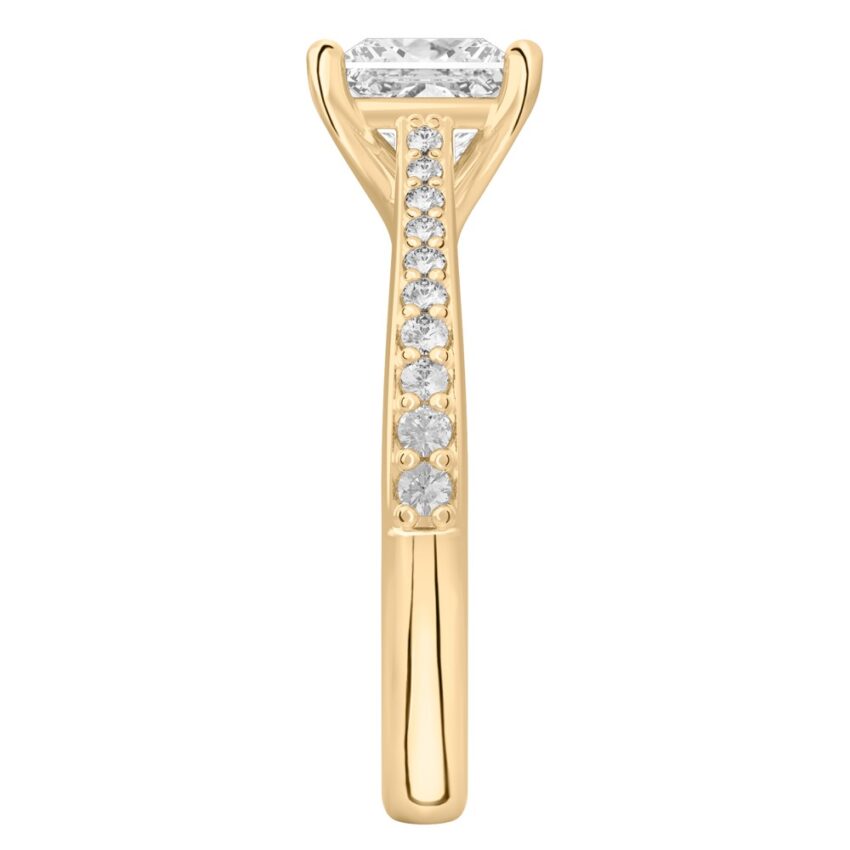 Side view of princess cut diamond tapered engagement ring in yellow gold