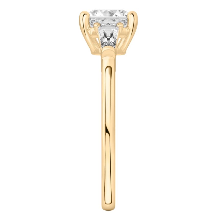 Side view of asscher cut diamond tapered baguette engagement ring in yellow gold