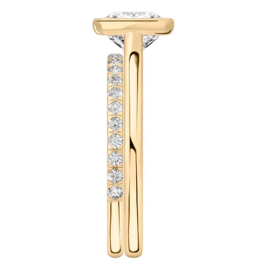 Side view of cushion cut diamond bezel engagement ring set yellow gold