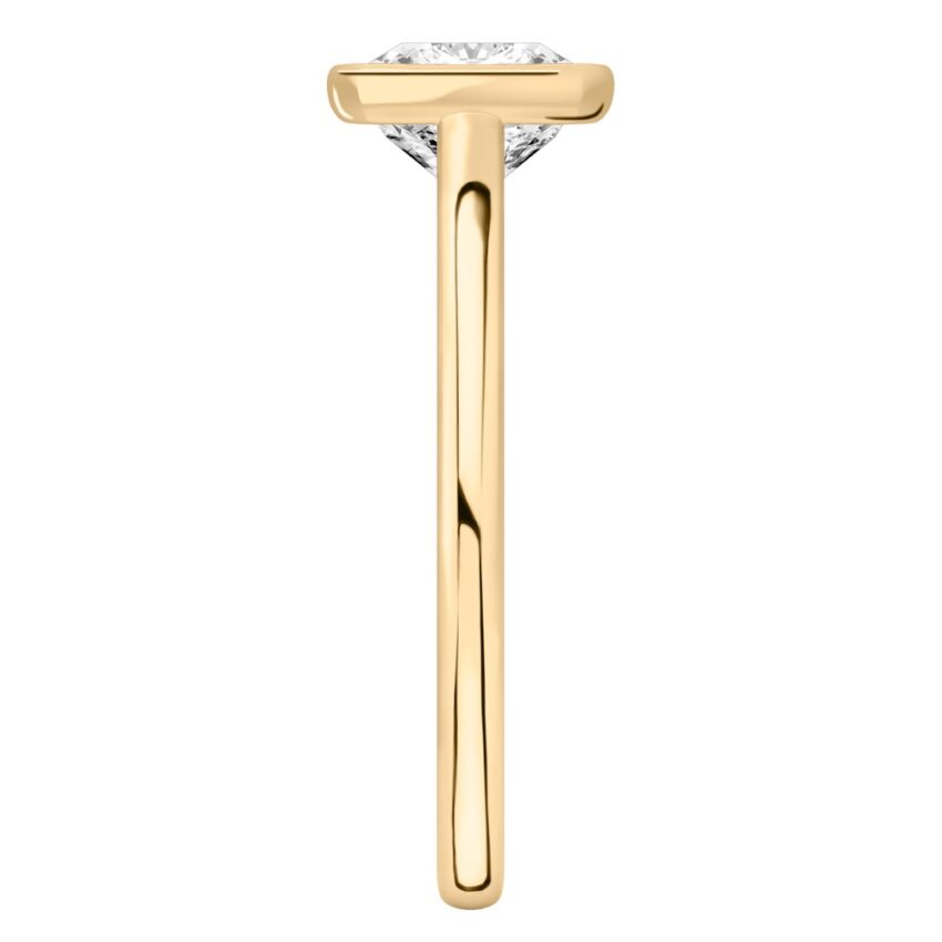 Side view of cushion cut diamond bezel engagement ring in yellow gold