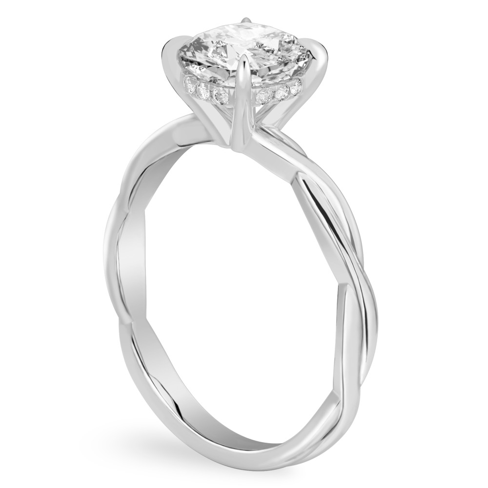 Angle view of cushion cut diamond twisted hidden halo engagement ring in white gold