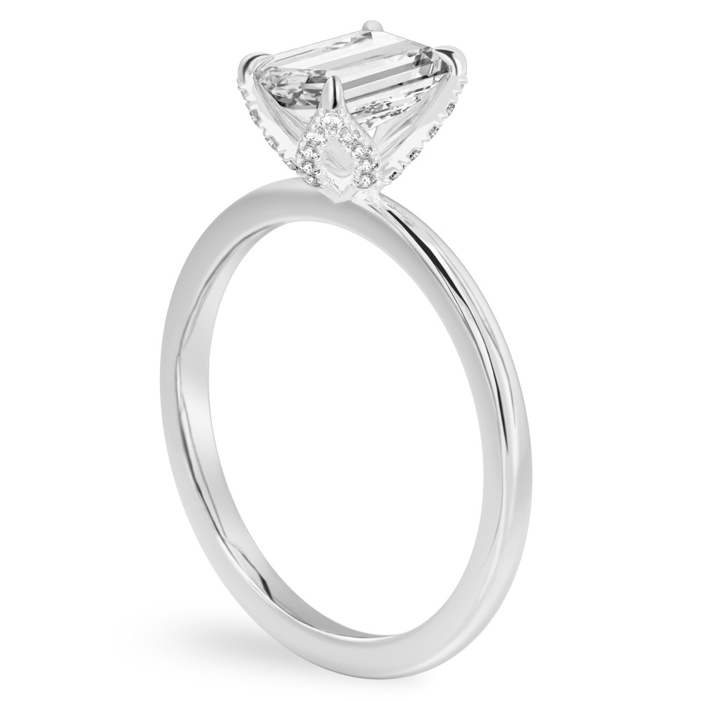 Angle view of emerald cut diamond pave petal prong engagement ring in platinum