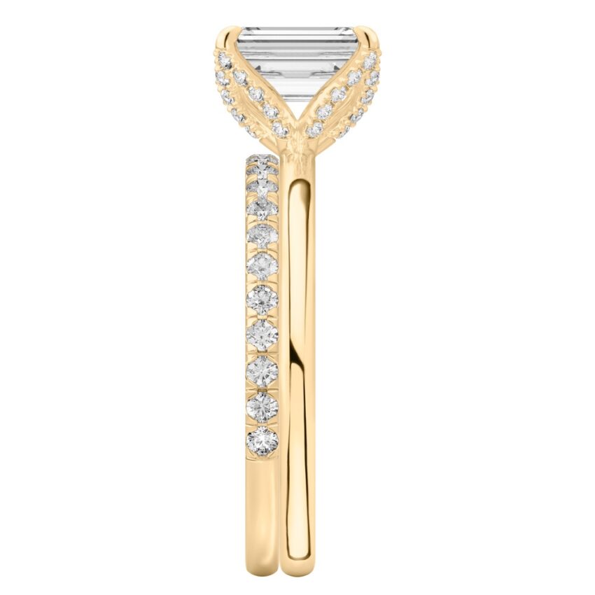 Side view of emerald cut diamond pave petal prong engagement ring set yellow gold