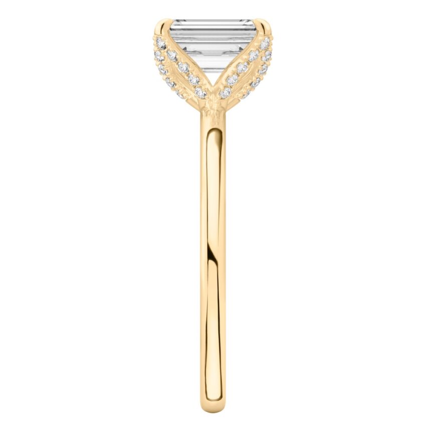Side view of emerald cut diamond pave petal prong engagement ring in yellow gold